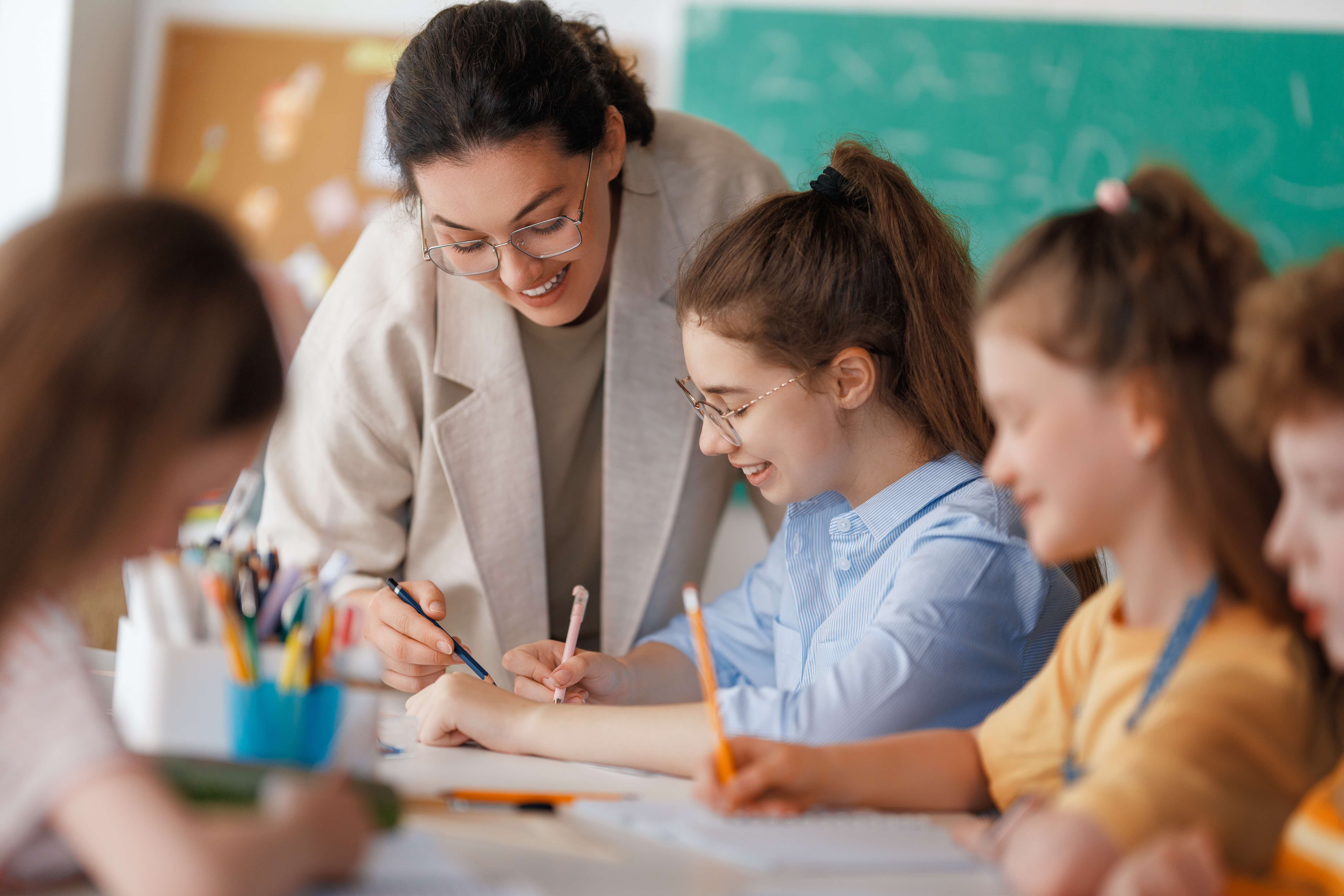 female ECT helping a group of students in a classroom